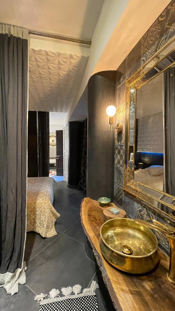 une salle de bain avec un lavabo en or et un lit dans l'établissement Riad Chocolat, à Marrakech 37 autres photos