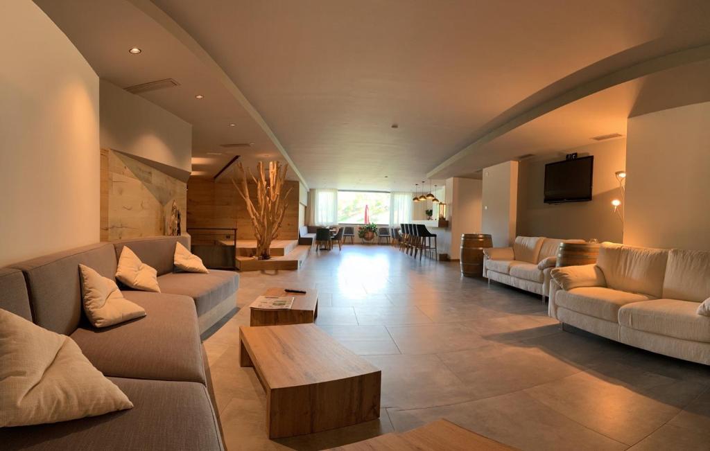 un grand salon avec des canapés et une télévision dans l'établissement Hotel Al Lago, à Lavarone