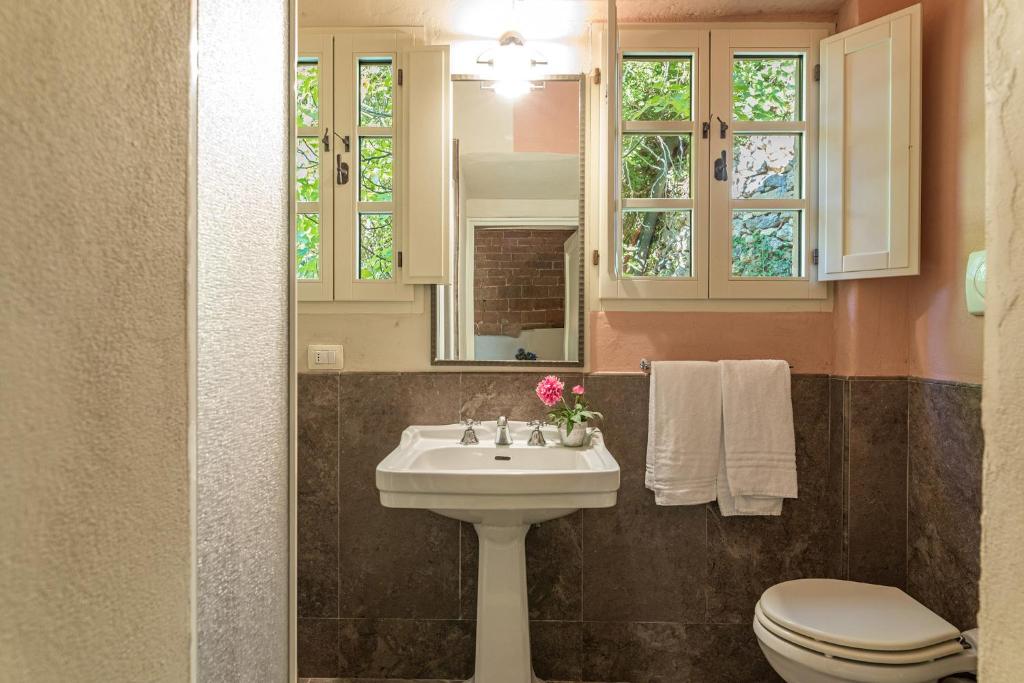 une salle de bain avec un lavabo, des toilettes et un miroir dans l'établissement Villa Linchiano, à Gambassi Terme