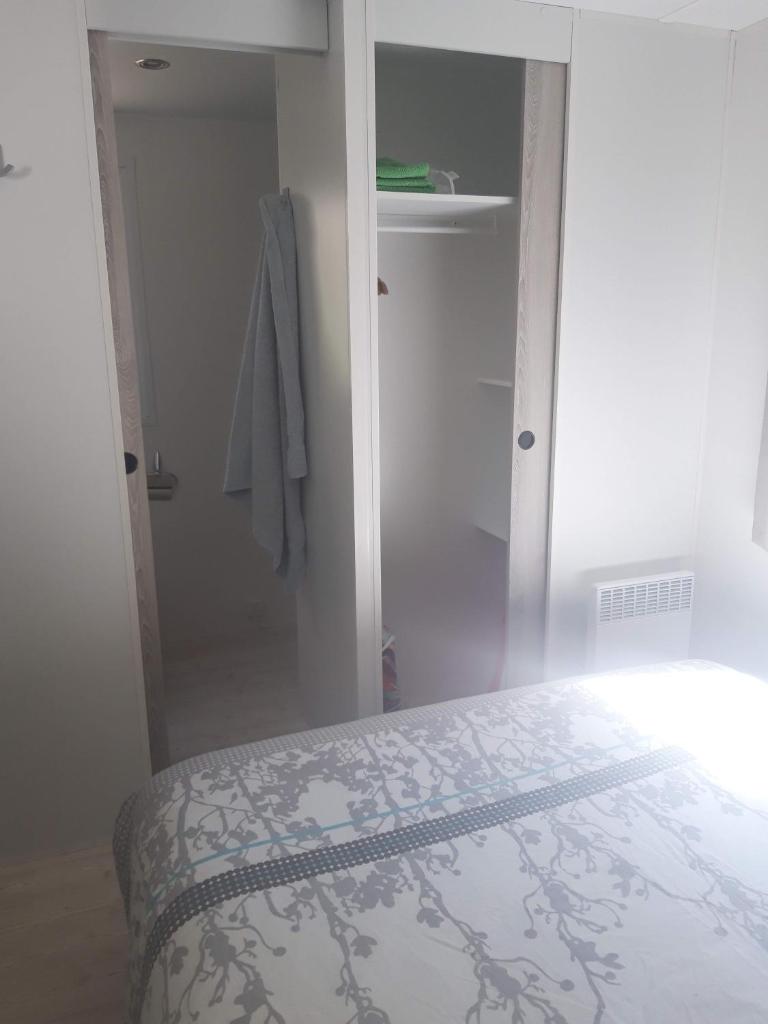 une chambre blanche avec un lit et un placard dans l'établissement Mobil home 6/8 places, à Vias
