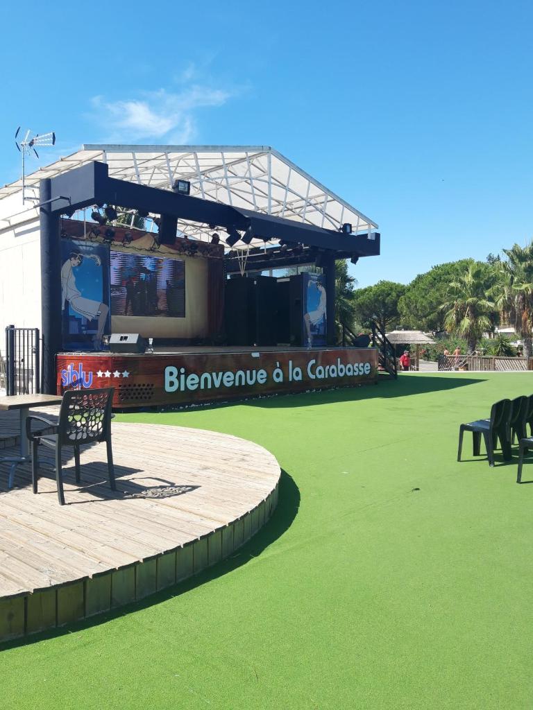 - une vue sur une scène avec des chaises et de l'herbe verte dans l'établissement Mobil home 6/8 places, à Vias