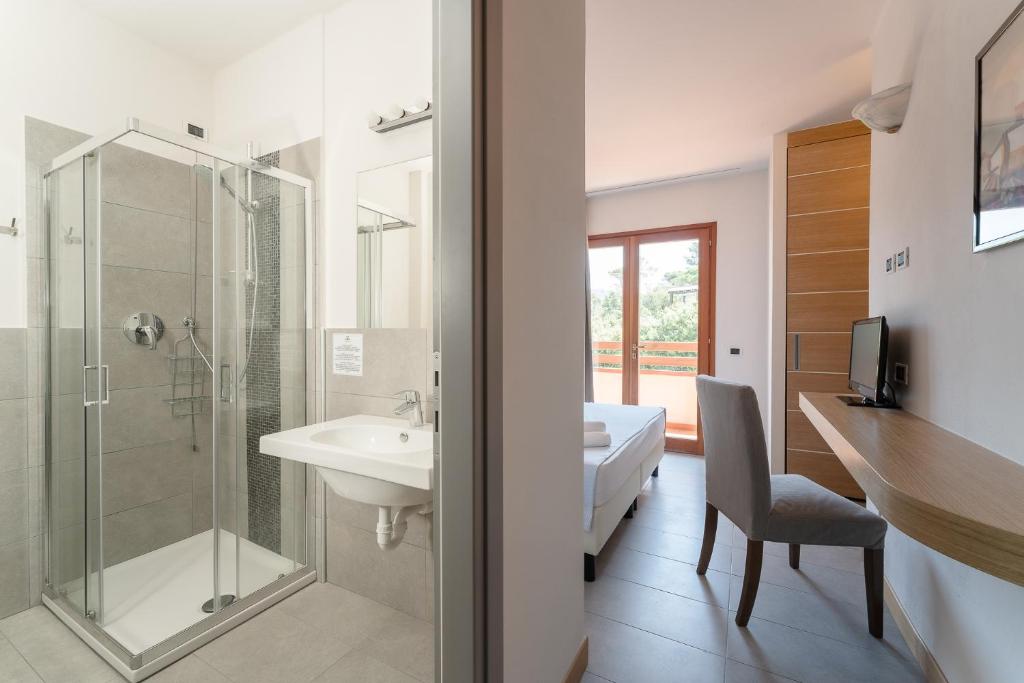 une salle de bain avec douche, lavabo et toilettes dans l'établissement Hotel Delfino, à Procchio 180 autres photos