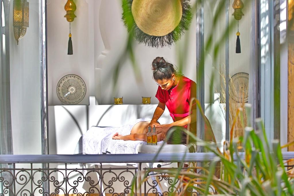 une femme assise sur un lit avec ses jambes dans l'établissement Riad Sashema, à Marrakech 37 autres photos