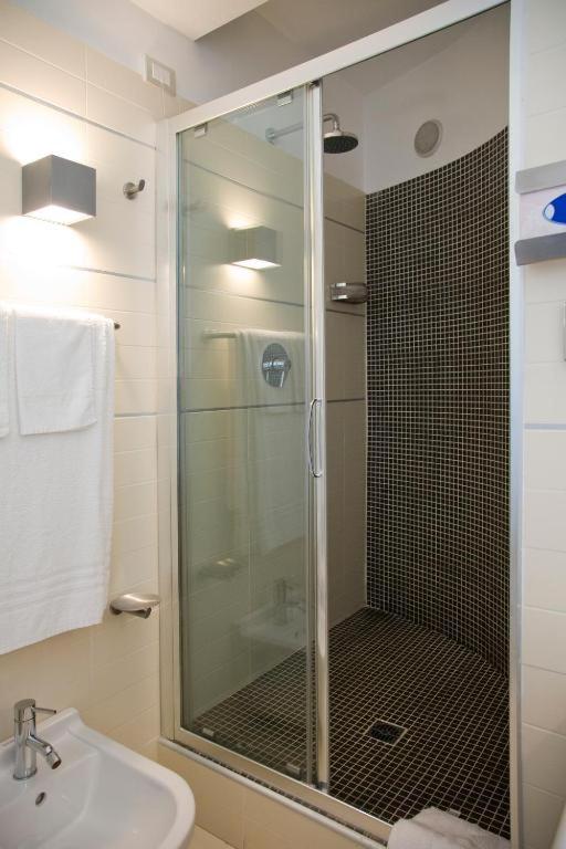 une salle de bain avec une douche en verre avec un lavabo dans l'établissement Hotel Le Piane, à Villammare