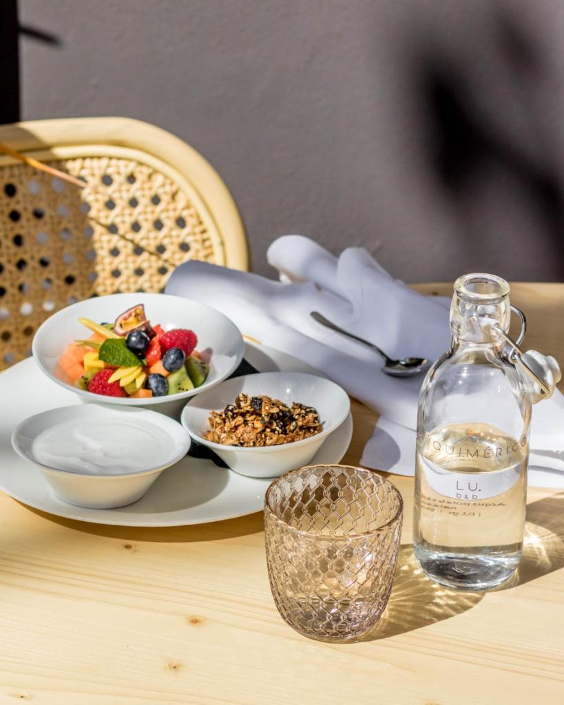 une table avec une assiette de nourriture et une bouteille d'eau dans l'établissement Lu. b&b, à Cervia