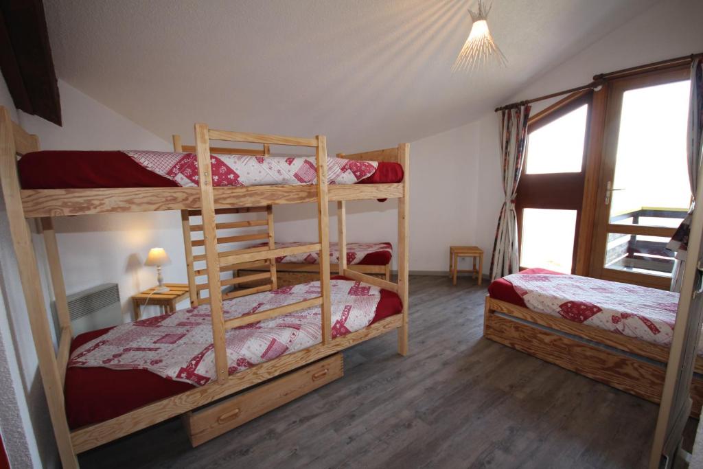 une chambre avec deux lits superposés et une fenêtre dans l'établissement Le Chalet de Bisanne, aux Saisies
