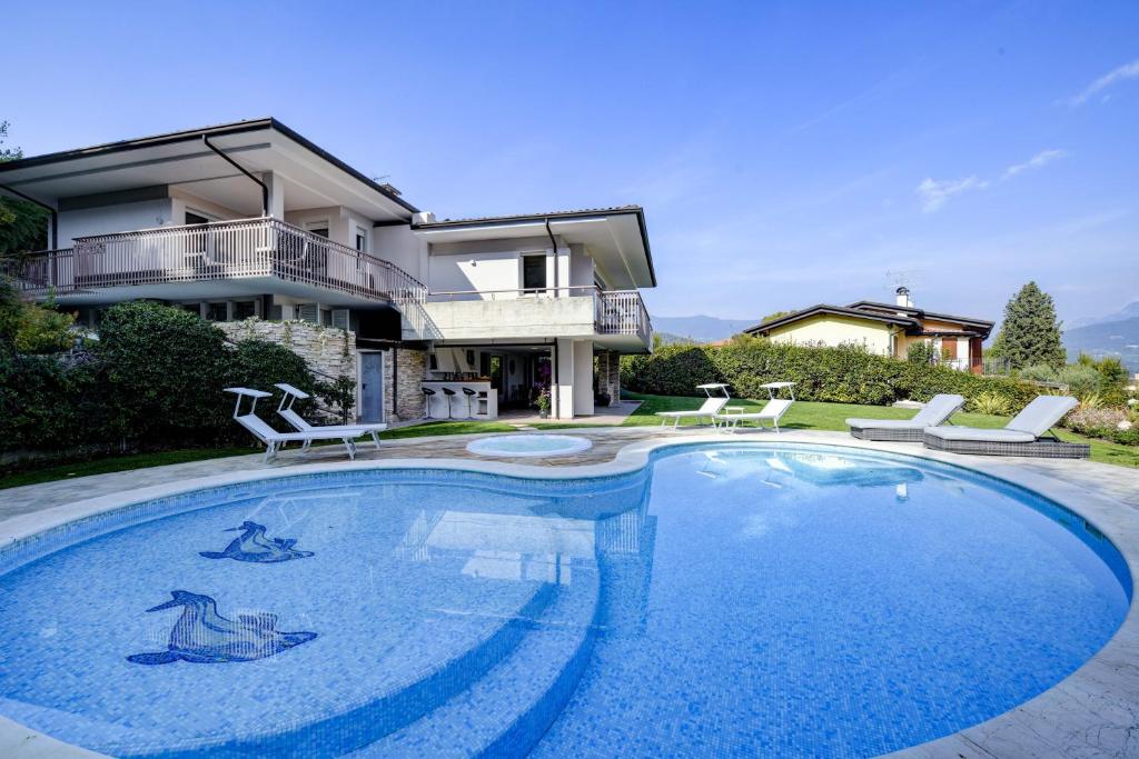 une grande piscine devant une maison dans l'établissement Villa Caterina, à Salò