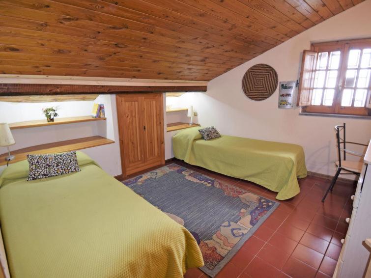 une chambre avec deux lits dans une pièce avec des plafonds en bois dans l'établissement Villa Mimosa, à Zafferana Etnea