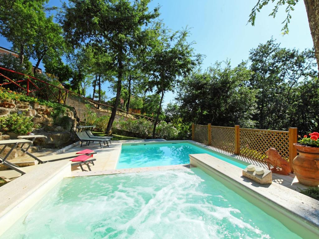 - une piscine avec une table et une chaise dans la cour dans l'établissement Villa Oleandra sul Lago by Interhome, à San Feliciano