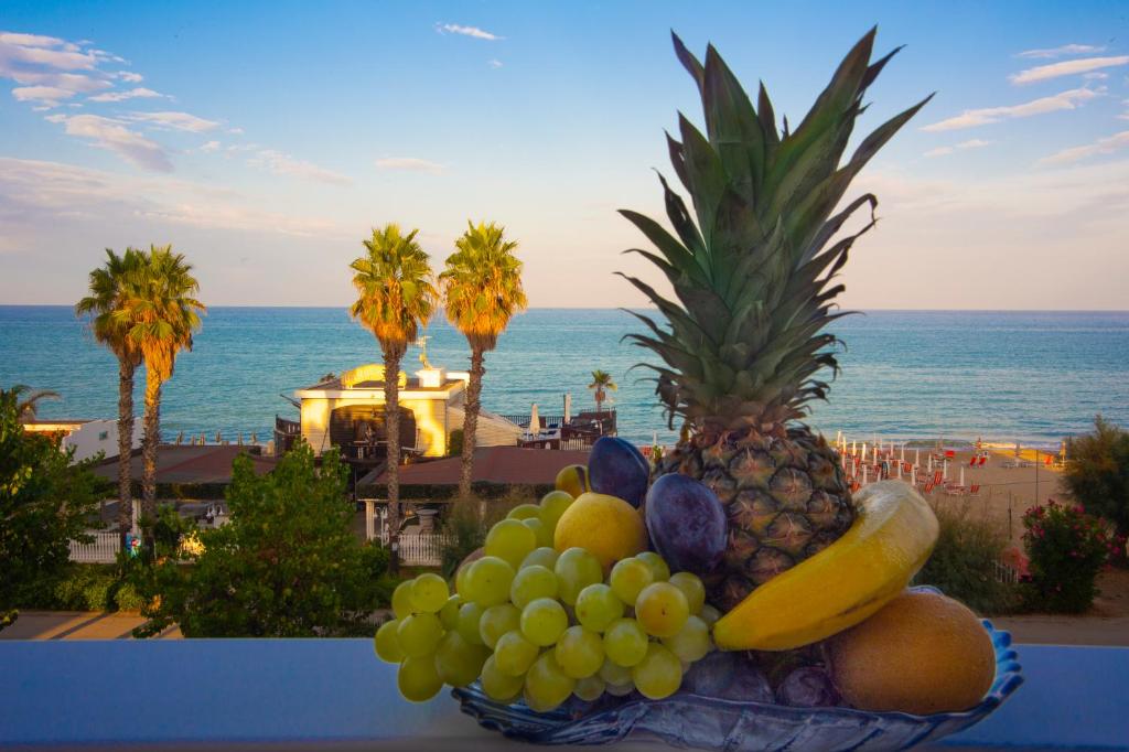 un bol de fruits sur une table avec vue sur l'océan dans l'établissement Hotel Flora, à Alba Adriatica