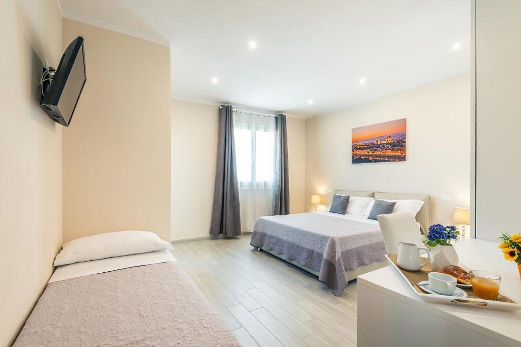 une chambre avec un lit et une télévision dans l'établissement Villa Le Terme, à Monsummano