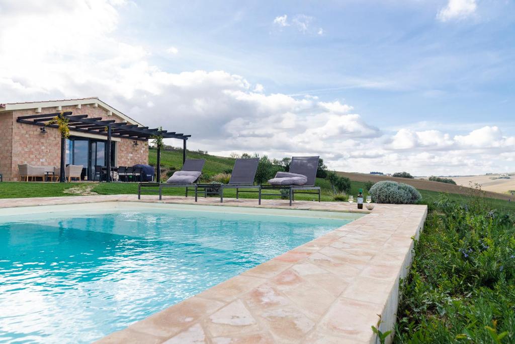 une piscine avec deux chaises et une maison dans l'établissement Villa Saltregna, à Cervidone