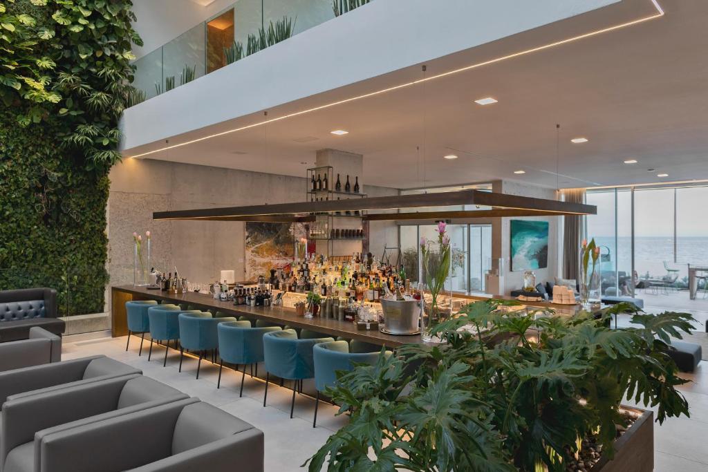 un restaurant avec des chaises bleues et un bar dans l'établissement Posia Retreat & Spa UNA Esperienze, à San Foca