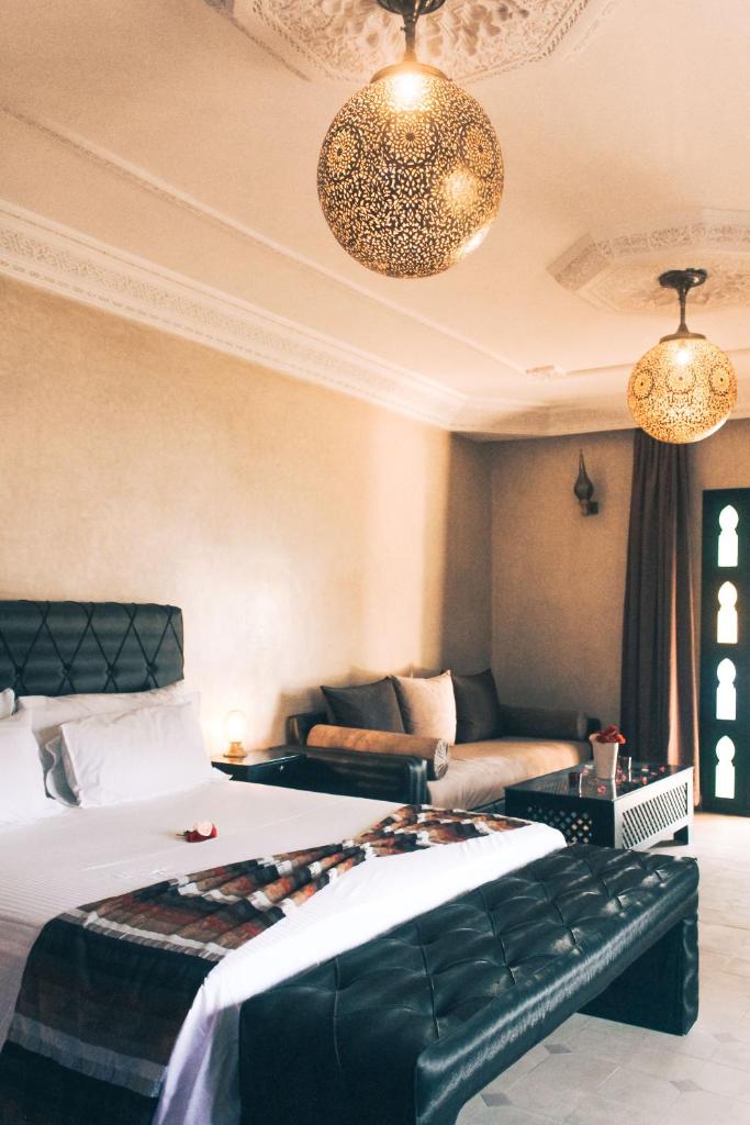 une chambre d'hôtel avec un lit et un canapé dans l'établissement Riad le Jasmin, à Taroudant