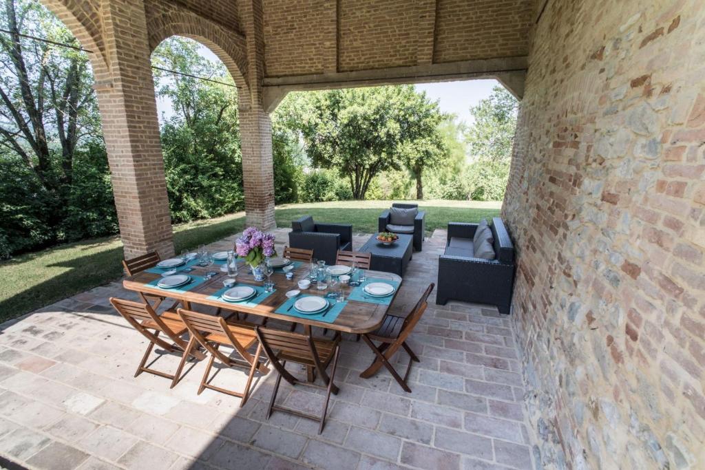 un patio extérieur avec une table et des chaises en bois dans l'établissement Villa Ca de Angeli - Tabiano Castle Country Villas, à Salsomaggiore Terme