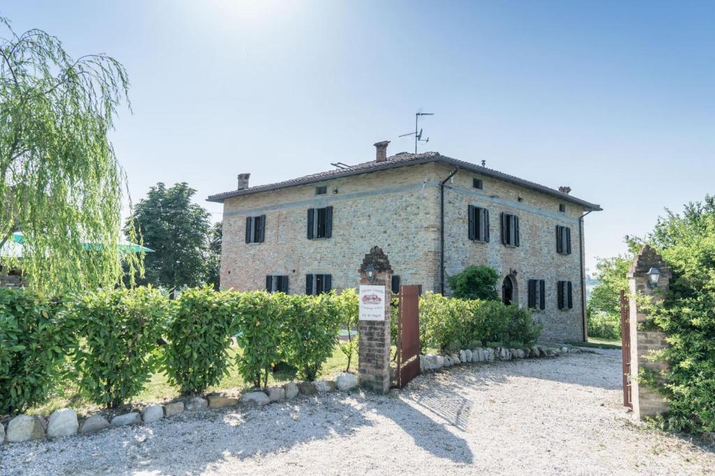 une ancienne maison en pierre avec une clôture devant elle dans l'établissement Villa Ca de Angeli - Tabiano Castle Country Villas, à Salsomaggiore Terme