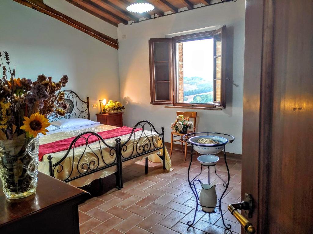 une chambre avec un lit, une table et une fenêtre dans l'établissement Il Poggio, à Montisi 41 autres photos