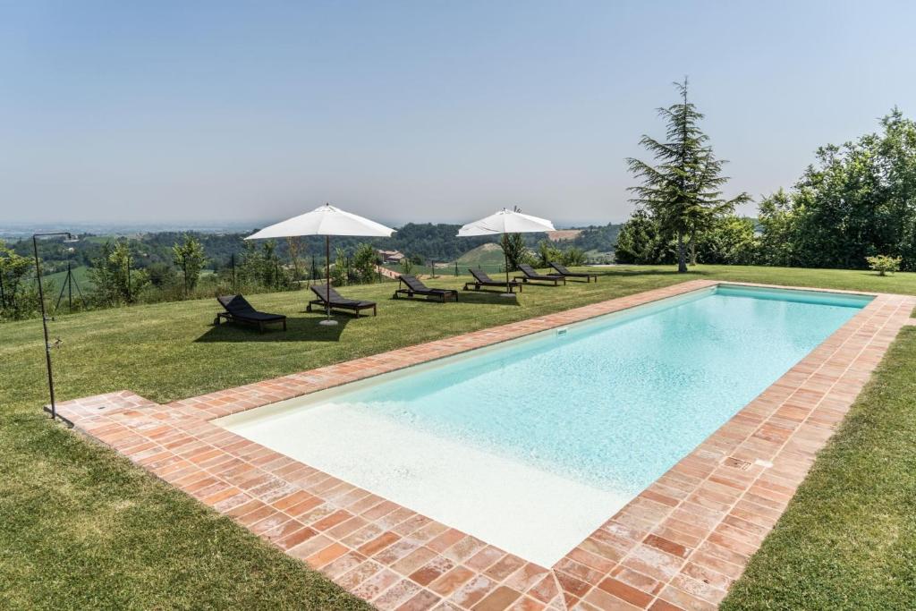 une piscine avec chaises et parasols dans une cour dans l'établissement Villa Ca de Poi - Tabiano Castle Country Villas, à Salsomaggiore Terme