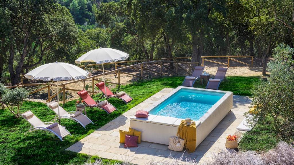 une piscine avec chaises et parasols dans une cour dans l'établissement Villa Zaca 6, Emma Villas, à Rio Marina