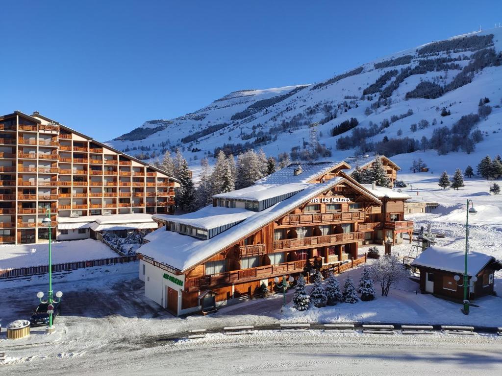 un hôtel dans les montagnes avec de la neige au sol dans l'établissement Panorama 360°, à Les Deux Alpes