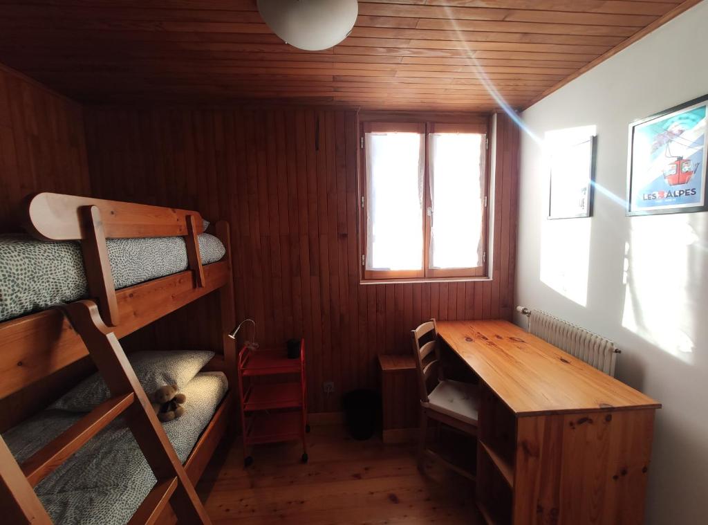 Cette chambre comprend un bureau, des lits superposés et une table. dans l'établissement Panorama 360°, à Les Deux Alpes