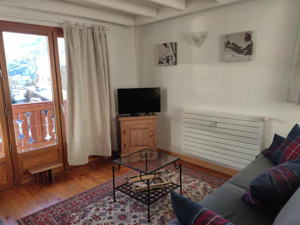 un salon avec un canapé et une télévision dans l'établissement Panorama 360°, à Les Deux Alpes