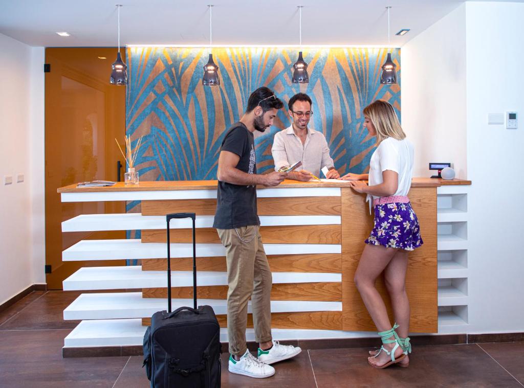 Un groupe de trois personnes debout à un comptoir dans l'établissement Park Oasi Resort, à Zambrone 128 autres photos