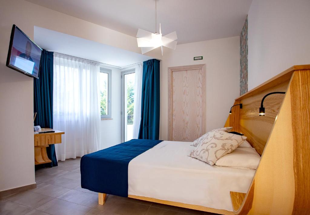 une chambre avec un lit et une télévision dans l'établissement Park Oasi Resort, à Zambrone