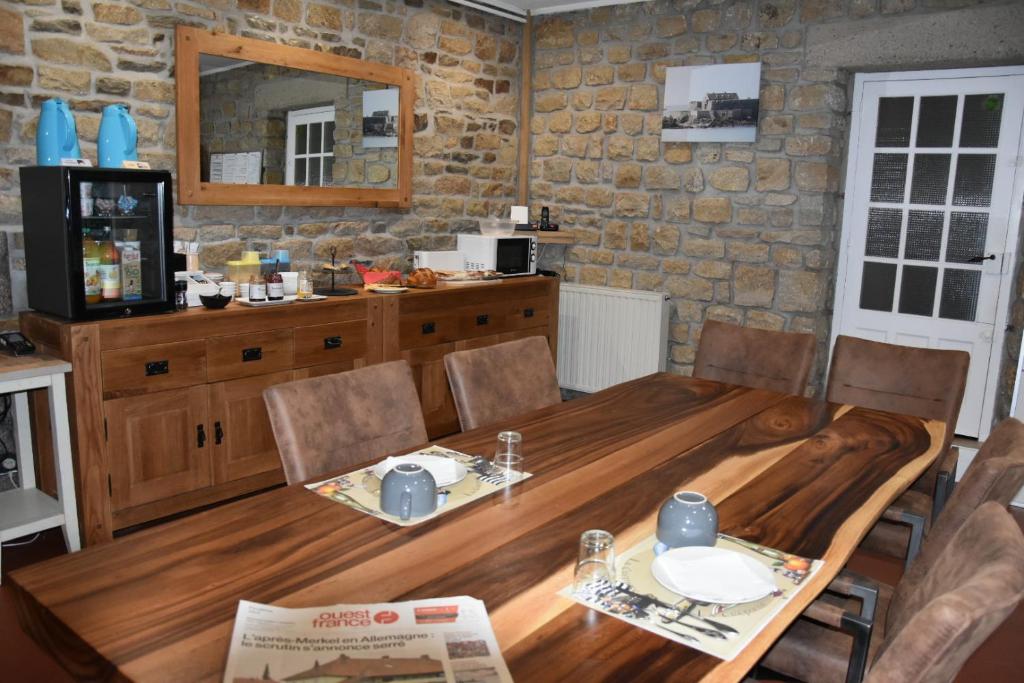 une salle à manger avec une table et des chaises en bois dans l'établissement GITE MAEN ROCH, à Val Couesnon