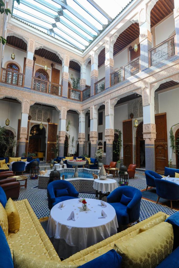 une grande chambre avec des tables et des chaises dans un bâtiment dans l'établissement Riad Myra, à Fès