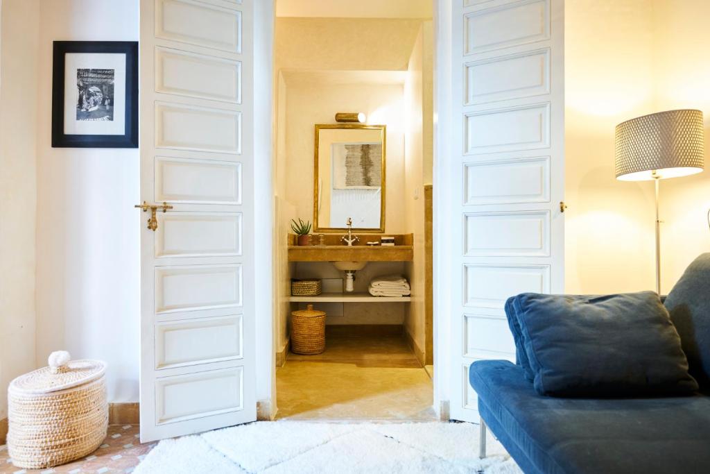 - un salon avec un canapé bleu et un lavabo dans l'établissement Riad Rafaele & SPA, à Marrakech