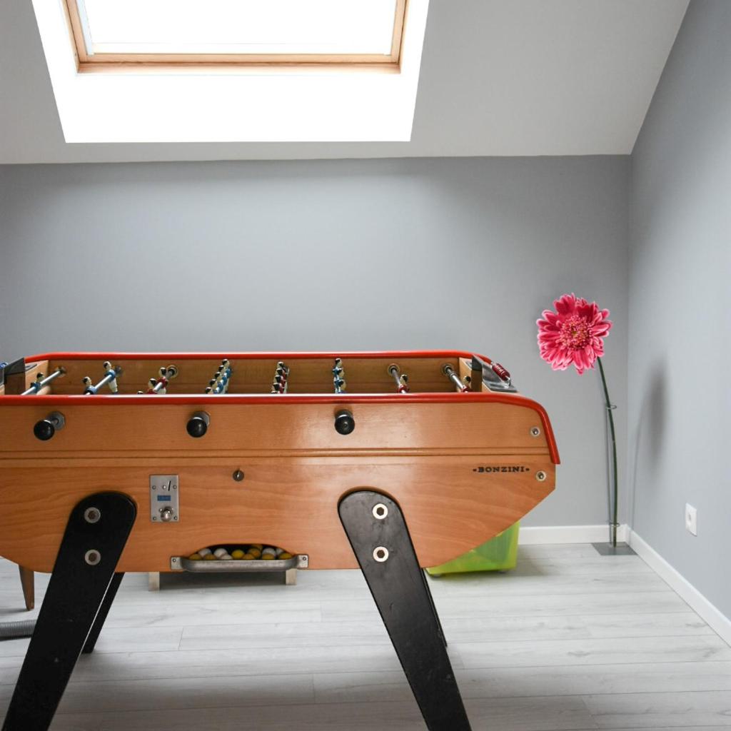 - une table en bois avec une fleur rouge dans l'établissement Gîte des ouches - piscine, à Civray