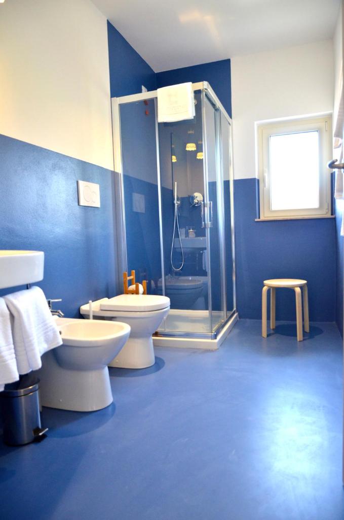 La salle de bains bleue est pourvue de 2 toilettes et d'une douche. dans l'établissement Petit Hotel, à Lido di Camaiore 68 autres photos
