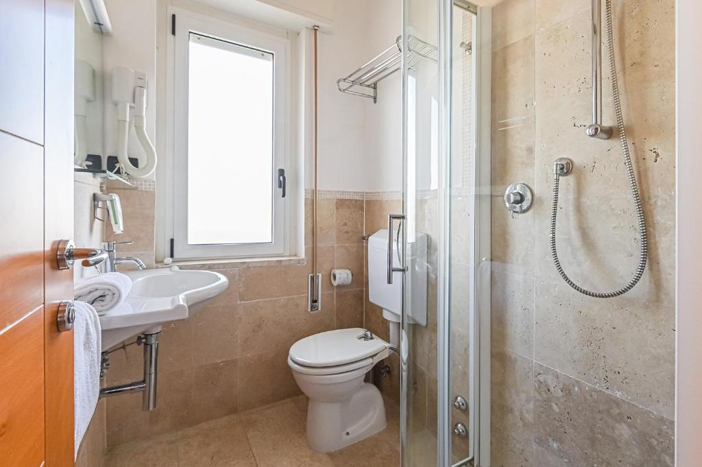 une salle de bain avec toilettes, lavabo et douche dans l'établissement Hotel City, à Milano Marittima