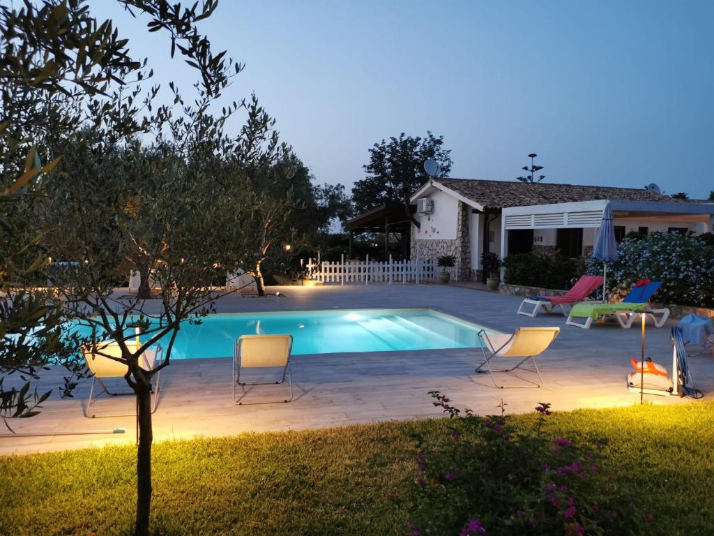 une arrière-cour avec une piscine, des chaises et une maison dans l'établissement VILLA HIBISCUS, à Castellammare del Golfo