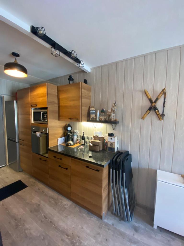 une cuisine avec des armoires en bois et un comptoir dans l'établissement STUDIO COCOONING SUPERDEVOLUY PIED DES PISTES, à Saint-Étienne-en-Dévoluy 16 autres photos