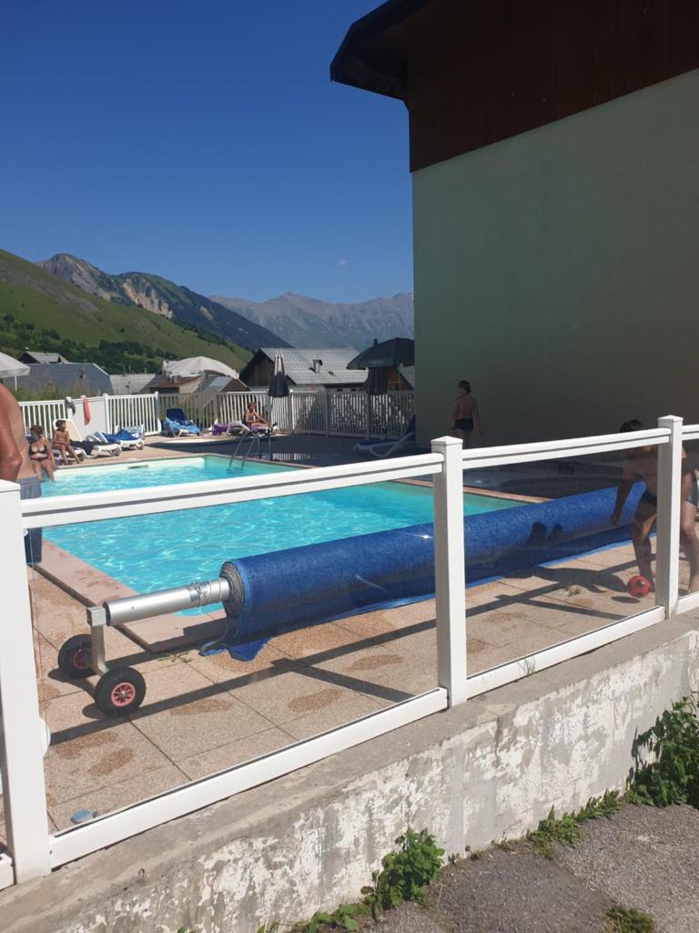 une piscine entourée d'une clôture blanche. dans l'établissement Saint-Sorlin D'Arves 4-6 personnes pied des pistes 310km de pistes tous niveaux, à Saint-Sorlin-dʼArves