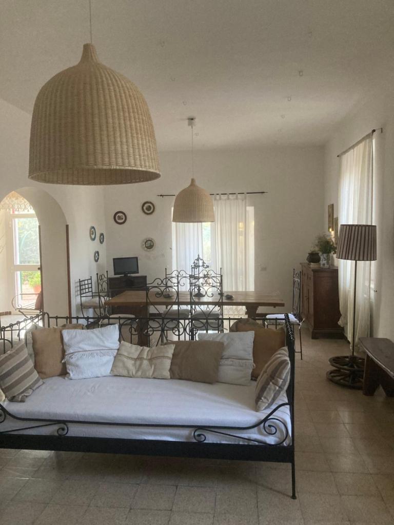 un salon avec un canapé et une salle à manger dans l'établissement La Villa de I Casali del Troscio, à Capalbio