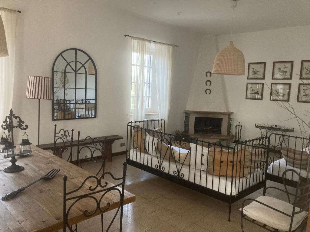 - un salon avec une cheminée, une table et des chaises dans l'établissement La Villa de I Casali del Troscio, à Capalbio