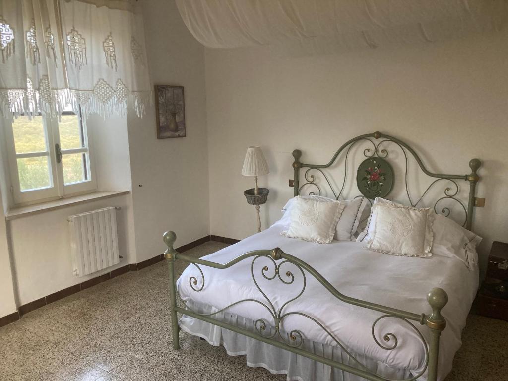 une chambre avec un lit blanc avec des oreillers blancs dans l'établissement La Villa de I Casali del Troscio, à Capalbio