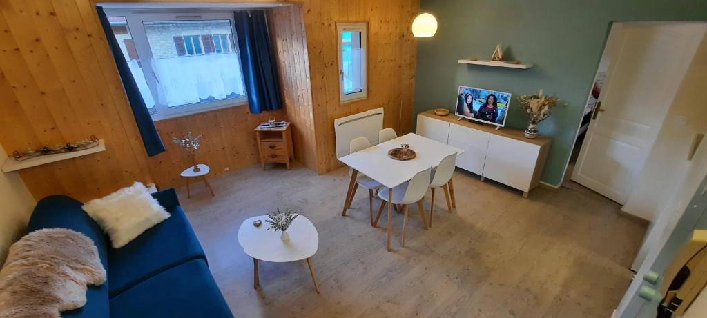 un salon avec un canapé bleu et une table dans l'établissement Au Coeur de Prémanon, à Prémanon