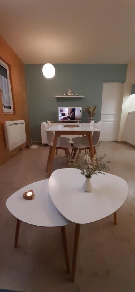 un salon avec une table et un bureau dans l'établissement Au Coeur de Prémanon, à Prémanon