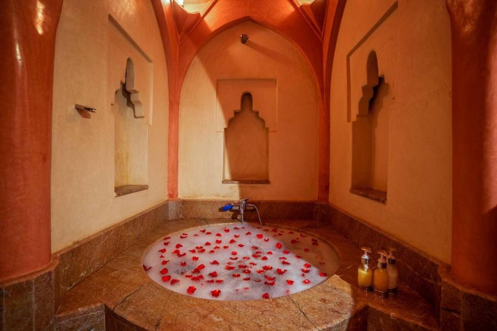 une salle de bains avec une baignoire remplie de roses rouges dans l'établissement Riad Safran et Cannelle & Spa, à Marrakech 36 autres photos