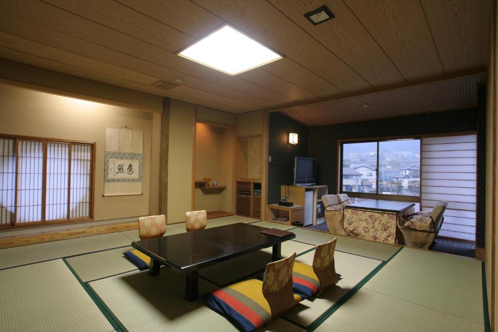 un grand salon avec une table et des chaises dans l'établissement Tsuki no Shizuka, à Matsumoto