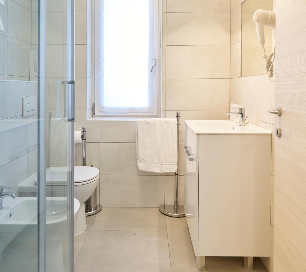 une salle de bain blanche avec un lavabo et des toilettes dans l'établissement Art Hotel Principe, à Lignano Sabbiadoro