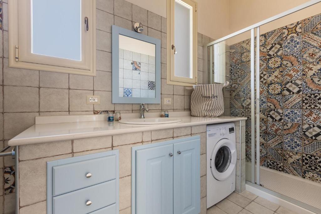 une salle de bain avec un lavabo et une machine à laver dans l'établissement Villa Dora by BarbarHouse, à San Pietro in Bevagna