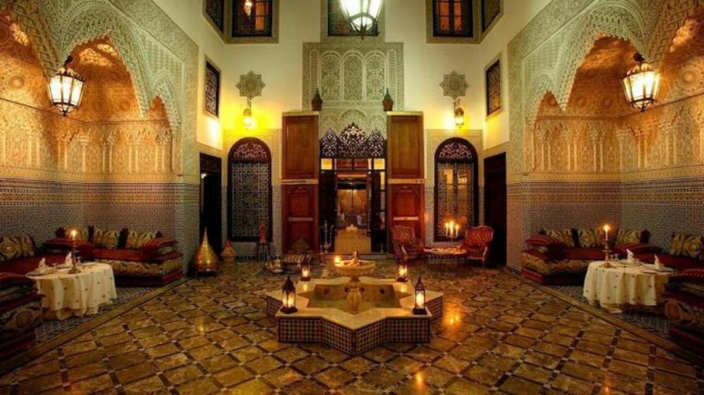 - un hall avec une grande salle dotée de tables et de chaises dans l'établissement Riad Pacha Palace, à Fès