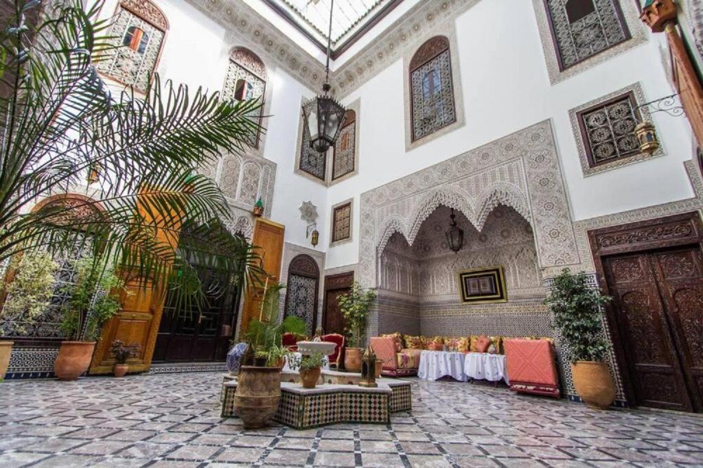 un hall avec une table et des chaises dans un bâtiment dans l'établissement Riad Pacha Palace, à Fès