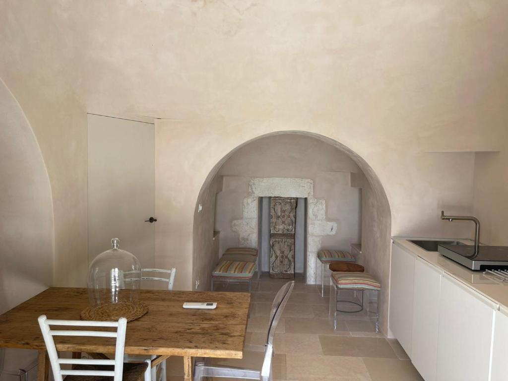 une cuisine et une salle à manger avec une table et des chaises dans l'établissement OSTUNI MIRROR trullo and mirror house, à Ostuni
