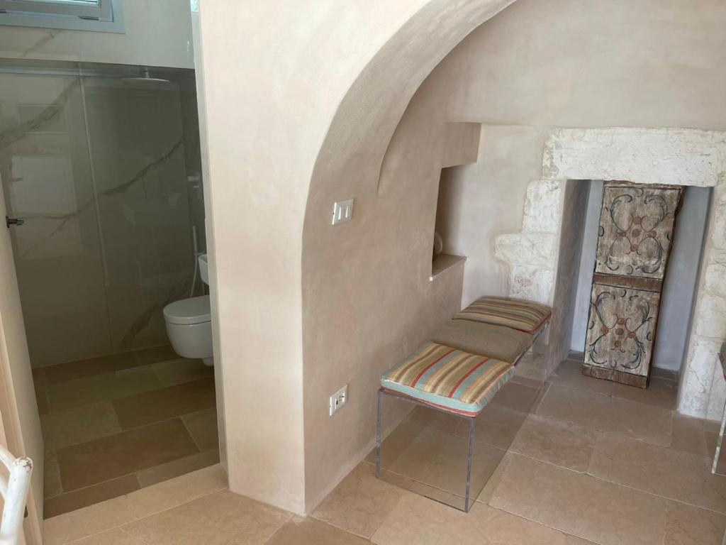 une salle de bain avec toilettes et banc et une douche dans l'établissement OSTUNI MIRROR trullo and mirror house, à Ostuni 34 autres photos